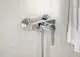 Brausearmatur in Chrom von Ideal Standard, montiert an einer hellen Wand, mit Handbrauseanschluss und einem Hebelmischer zur Temperatur- und Durchflussregelung.